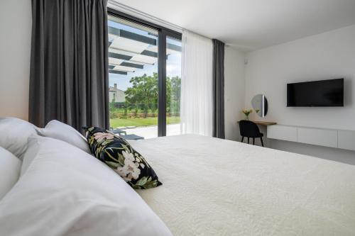 a bedroom with a large bed with a large window at Villa Celi whit heating pool Fazana Pula in Fažana