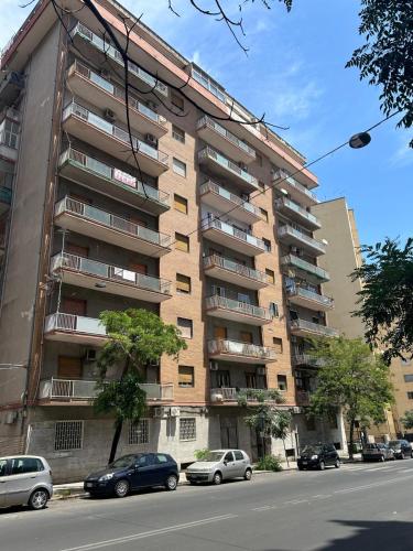 a tall apartment building with cars parked in front of it at EFFE Home in Catania