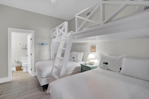 Un dormitorio blanco con 2 camas y una escalera en Phoenix VII 7116 by Liquid Life, en Orange Beach