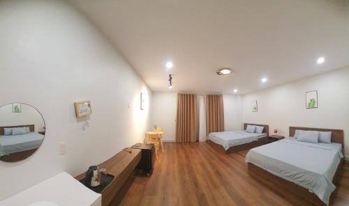 a hotel room with two beds and a mirror at Nhà nghỉ Rico in Rạch Giá