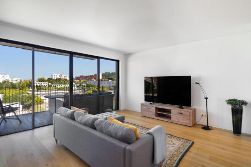 a living room with a couch and a flat screen tv at WHome History and Comfort, Luxurious Living in Benfica in Lisbon