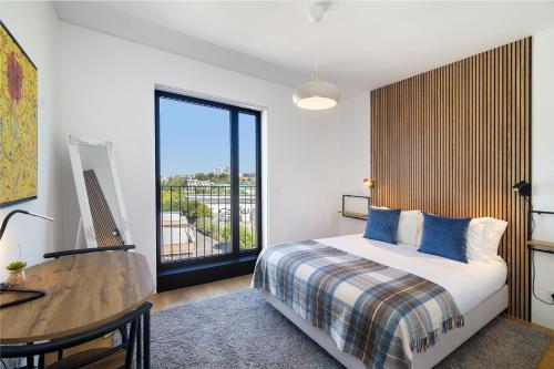 a bedroom with a bed and a desk and a window at WHome History and Comfort, Luxurious Living in Benfica in Lisbon