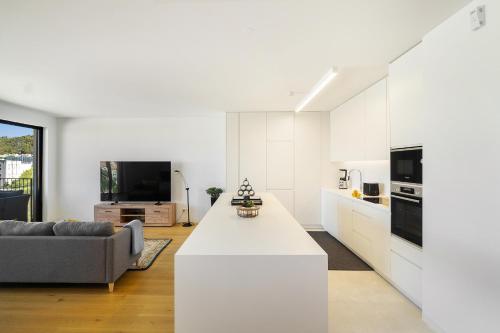 a white kitchen and living room with a couch at WHome History and Comfort, Luxurious Living in Benfica in Lisbon