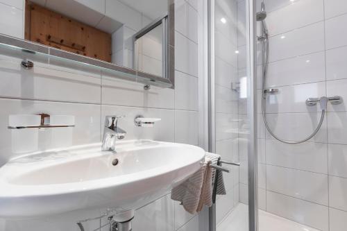 a white bathroom with a sink and a shower at Apart Schneider in Ischgl