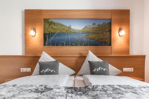 a bedroom with two beds and a painting on the wall at Apart Schneider in Ischgl