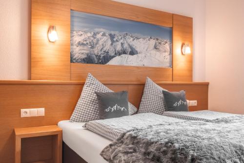 a bedroom with two beds and a picture on the wall at Apart Schneider in Ischgl
