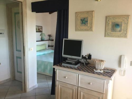 a bedroom with a desk with a computer monitor on a counter at Villetta mare Erica in Santa Teresa Gallura