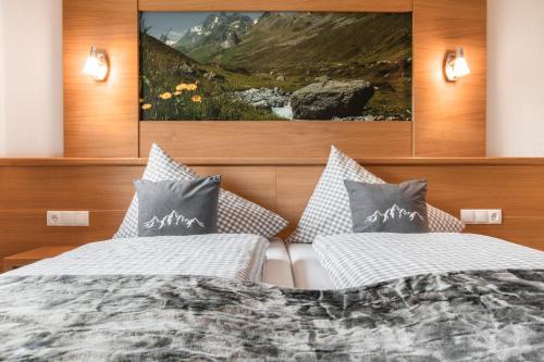 a bedroom with two beds and a painting on the wall at Apart Schneider in Ischgl