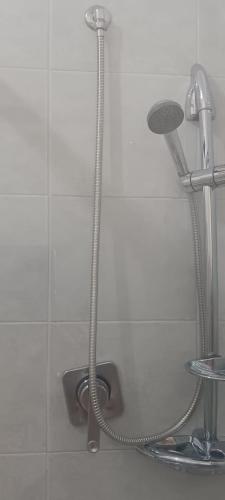 a shower hose hooked up to the wall of a bathroom at SWEET Apartment in San Giorgio Ionico