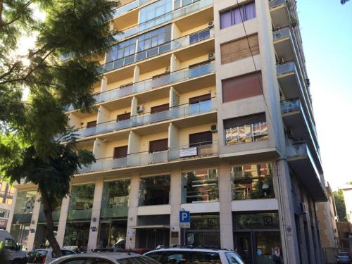 a tall building with cars parked in front of it at Eh13 Luxury Accommodation in Catania