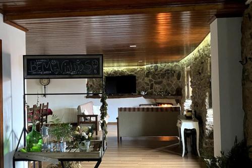 a living room with a table and a stone wall at Casa Torre do Sino in Montalegre