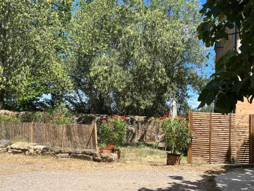 a garden with a wooden fence and a tree at SCI Domaine Saint Martin le grand in Béziers