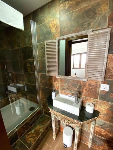 a bathroom with a sink and a tub and a mirror at Casa Torre do Sino in Montalegre
