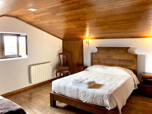 a bedroom with a large bed and a wooden ceiling at Casa Torre do Sino in Montalegre
