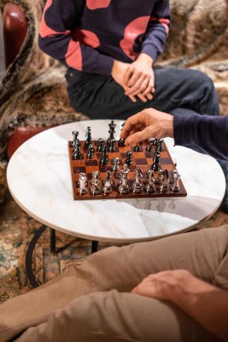 two people playing a game of chess on a table at Villa Carona Hotel & Spa in Carona