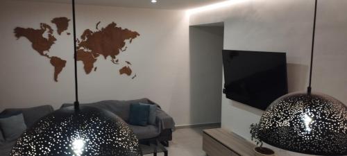 a living room with two pendant lights and a television at Kallia Sea Breeze - 3 Bedroom Apartment in Rhodes Town