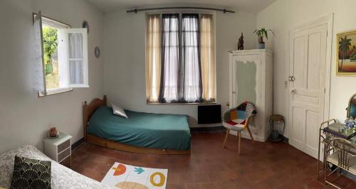 a bedroom with a green bed and a window at Les petites Mirabelles in Noyers-sur-Cher