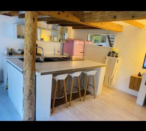 une cuisine avec un grand comptoir et des tabourets. dans l'établissement Surf House avec jardin dans quartier de Standing entre mer et vignes, à Saint-Cyr-sur-Mer