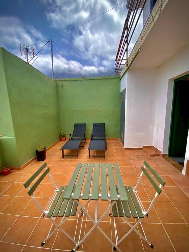 a room with three chairs and a green wall at ApKanariooo in Frontera