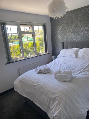 a bedroom with a white bed with towels on it at Manor Close in Wrafton
