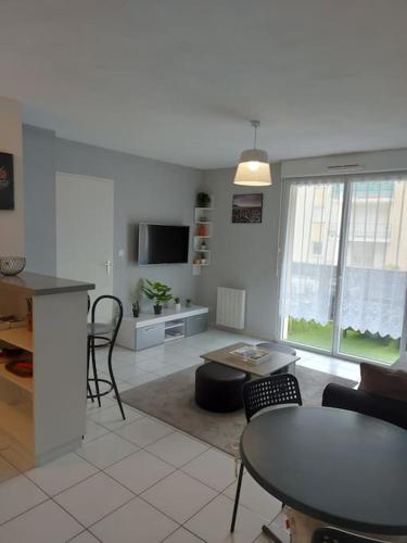 une cuisine et un salon avec une table et des chaises dans l'établissement Bel Appartement Confort T2, à Lannion