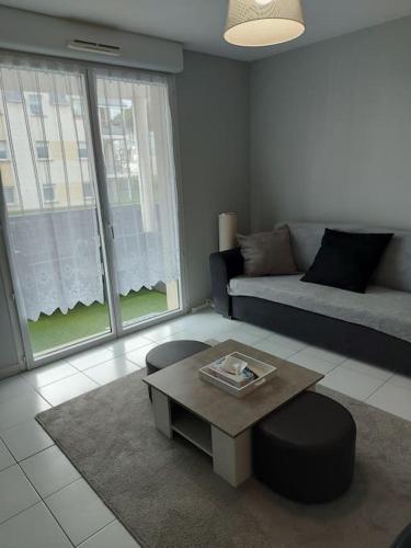 un salon avec un canapé et une table basse dans l'établissement Bel Appartement Confort T2, à Lannion
