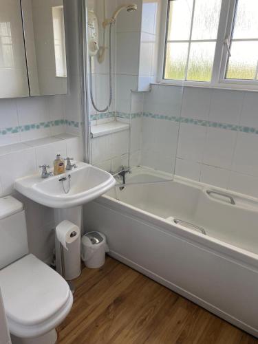 a bathroom with a tub and a sink and a toilet at Manor Close in Wrafton
