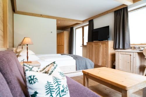 a hotel room with a bed and a tv at Hotel Arnaria in Ortisei