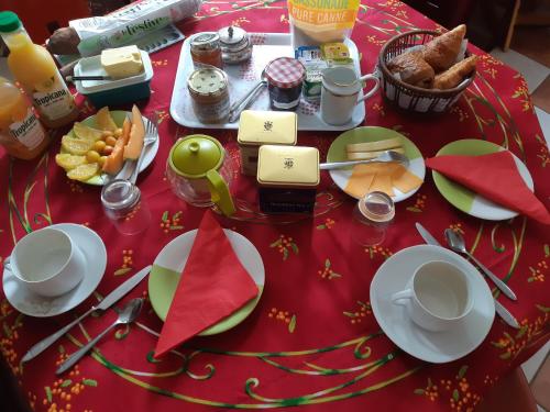 une table avec un tissu de table rouge et de la nourriture dans l'établissement le petit chemin, à Bougival