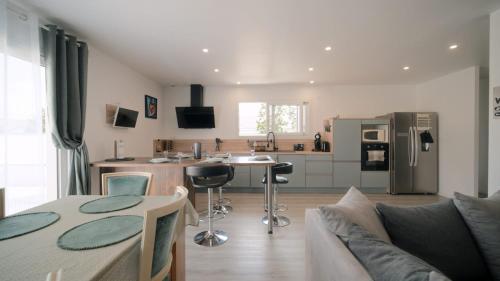 une cuisine et un salon avec une table et un canapé dans l'établissement Belle Villa Contemporaine 10/12 personnes, à Pont-du-Château