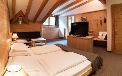 a bedroom with a large bed and a television at Hotel Arnaria in Ortisei