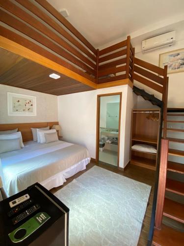 a bedroom with two bunk beds and a mirror at Hotel Aromas de Penedo in Penedo