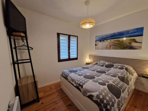 une chambre avec un lit et une télévision dans l'établissement Maison 6 pers Evasion Landaise proche plage et à côté du lac, à Vielle-Saint-Girons