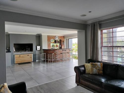 a living room with a couch and a kitchen at Champers with a view in Cape Town