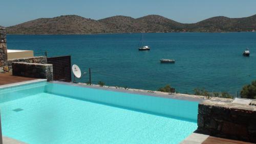 a swimming pool with a view of the water at Andromeda Sea View Villa in Epáno Eloúnda