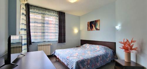 a small bedroom with a bed and a window at Hotel Bijou in Burgas