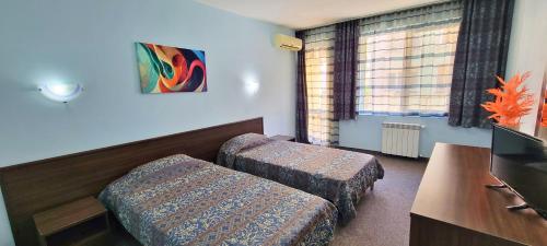 a hotel room with two ottomans and a television at Hotel Bijou in Burgas