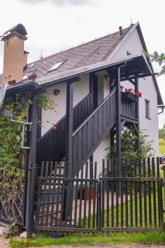 a white house with a black fence at Apartmán Rozárka u Lemberka in Liberec