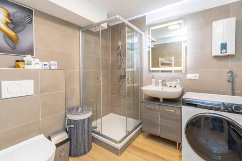 a bathroom with a shower sink and a washing machine at Haus mit großen Garten in Dreieich