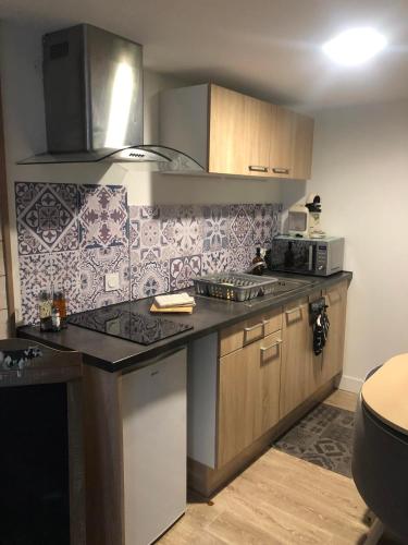 une cuisine avec un évier et un plan de travail dans l'établissement La Bichetière cœur de ville, à Granville