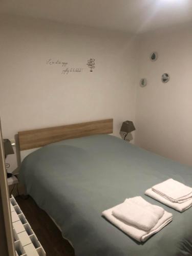 une chambre avec un lit avec deux serviettes dessus dans l'établissement La Bichetière cœur de ville, à Granville