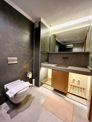 a bathroom with a white toilet and a sink at Kaleli Deluxe Homes in Kaş