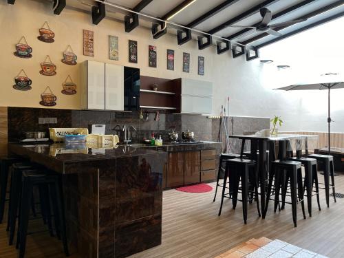 a kitchen with a bar with stools in it at Villa Klebang Beach 25Pax 6Bedroom Indoor Pool Full AirConditioned near TOWN in Melaka