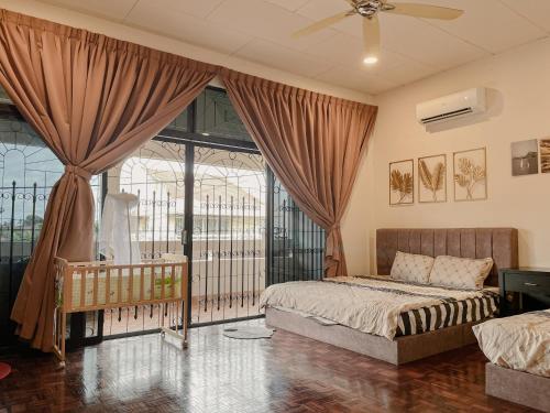 a bedroom with a bed and a large window at Villa Klebang Beach 25Pax 6Bedroom Indoor Pool Full AirConditioned near TOWN in Melaka