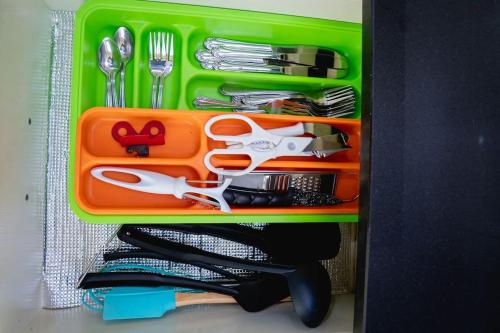 a green tray with scissors and other utensils at Nice And Modern with king size bed in Praia