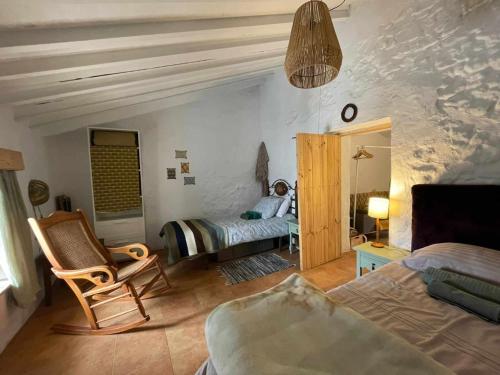 sypialnia z łóżkiem i krzesłem w pokoju w obiekcie Casa Shyshka country cottage w mieście Periana