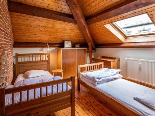 deux lits dans une chambre avec plafonds en bois dans l'établissement Appartement duplex le montagne de la villa Chanterive, à La Bourboule