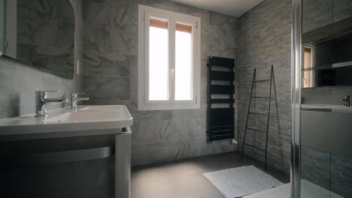 łazienka z umywalką, prysznicem i oknem w obiekcie Agréable Villa pour 8 personnes w mieście Pont-du-Château