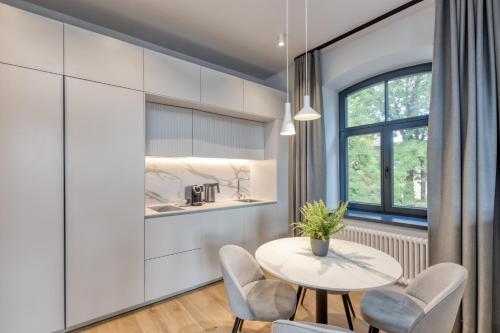 a kitchen and dining room with a table and chairs at Apartments Vitenberg in Cēsis