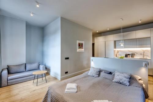 a bedroom with a large bed and a chair at Apartments Vitenberg in Cēsis